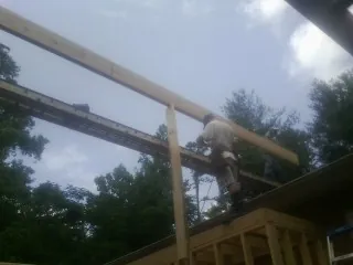 Carpenter setting a ridge beam over a new addition frame — Ice Dam Removal by Roofing Brothers in Collegeville