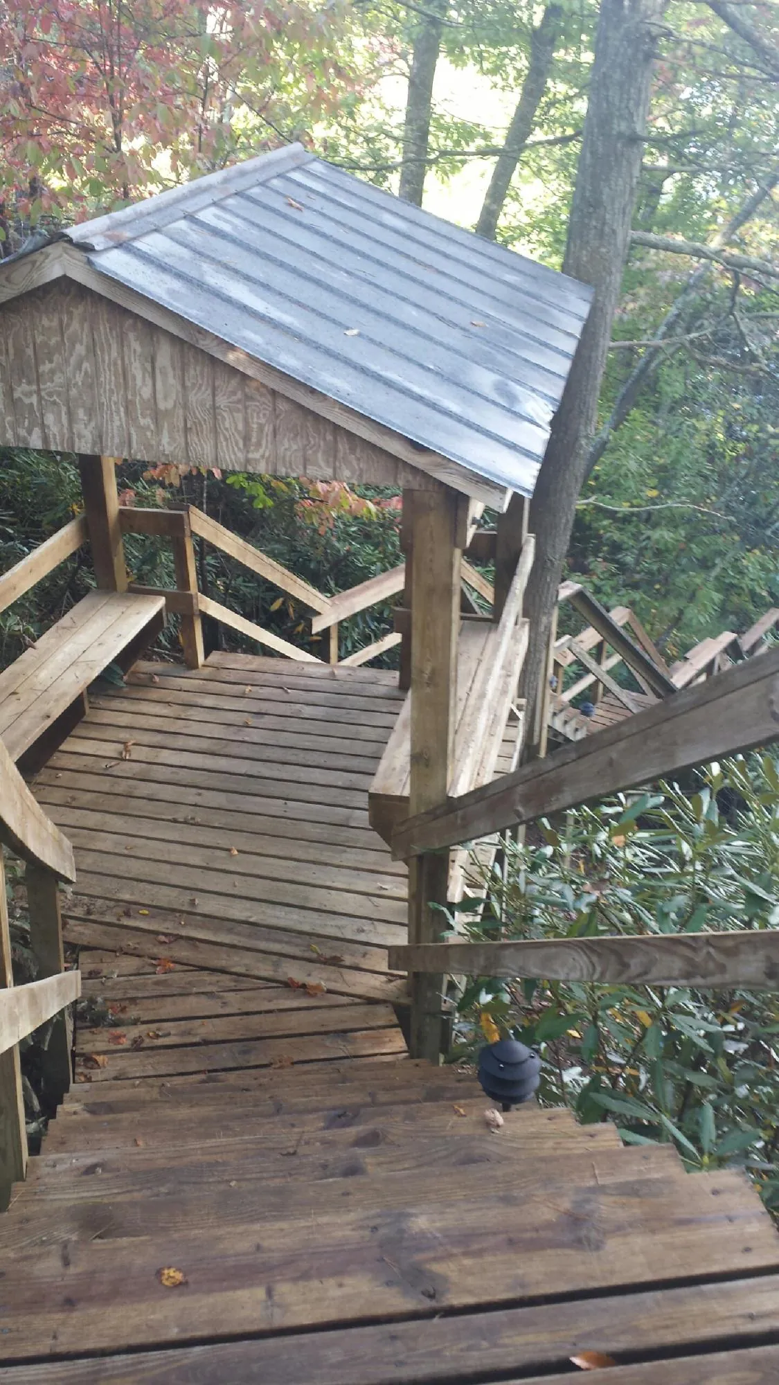 Metal roofed shelter over wooden steps on a wooded walkway — Skylight Repair & Installation work by our crew in Collegeville